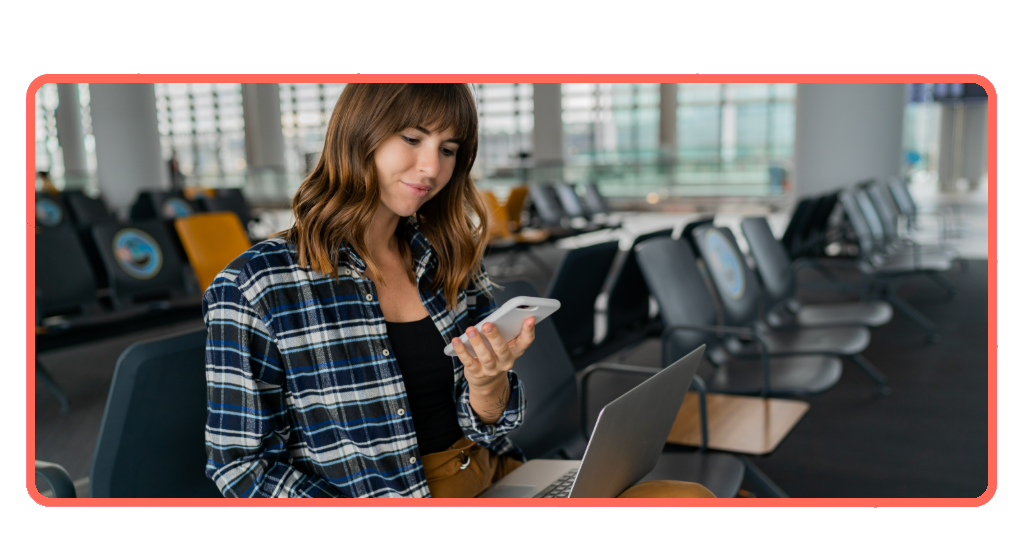 Airport passenger with smartphone and laptop waiting in terminal