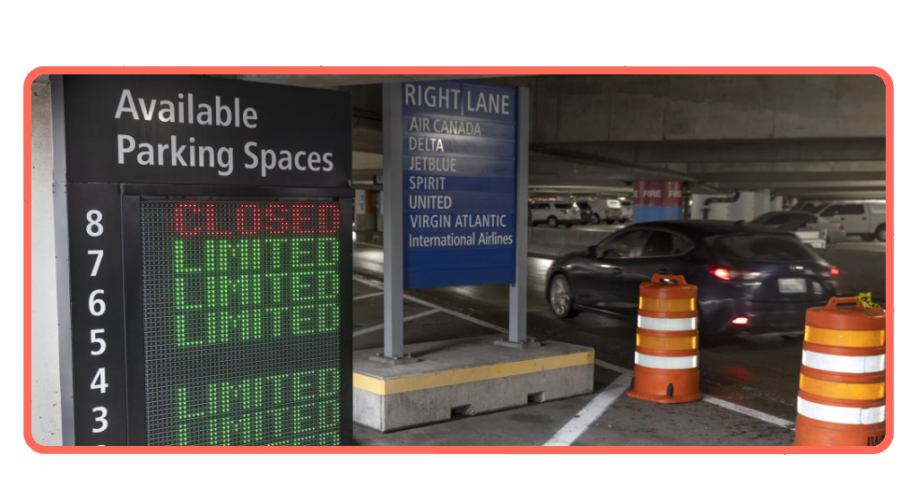 Airport parking lot with cars parked in rows near a terminal